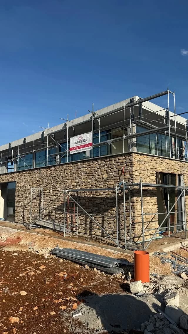 Magnus Leader construction site — modern building with stone facade